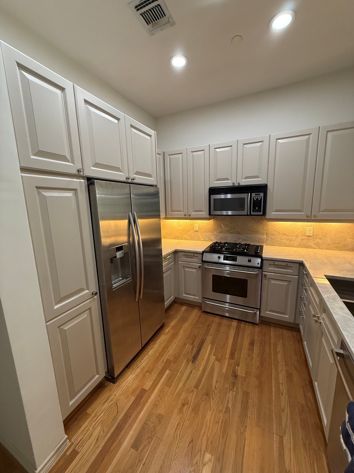 Newly remodeled kitchen with white cabinets and stainless appliances